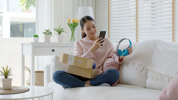 Woman sitting on a couch with a pair of headphones